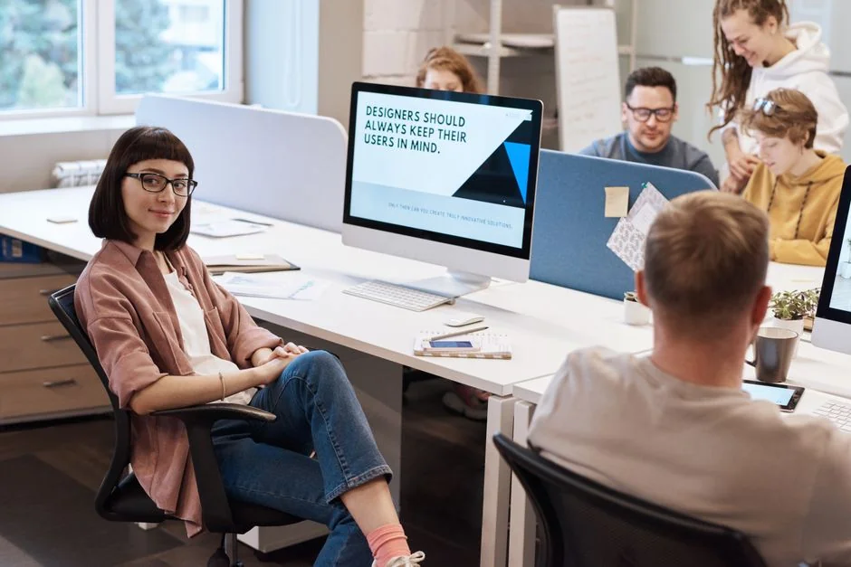A stylish workspace featuring a laptop and monitors displaying design software.